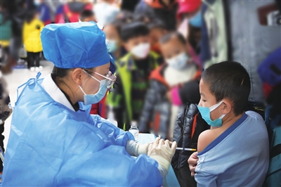 11月27日，在银川市西夏区贺兰山体育场方舱接种点，一名儿童正在接种新冠疫苗。 本报记者  季正  摄