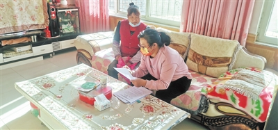 <p>　　牛香玉（右）给村民讲解贷款优惠政策。（图片由受访者提供）　　</p>