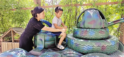 <p>　　王慧陪儿子玩坦克玩具车。</p>