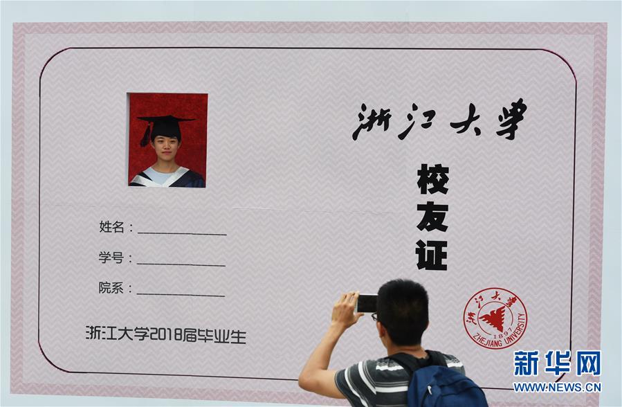 6月28日,学生在拍摄浙江大学校友证照片 新华社发(龙巍 摄)