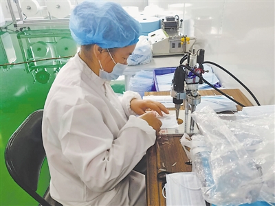 <p> 宁夏泉水药业有限公司工人给口罩订耳带。</p>