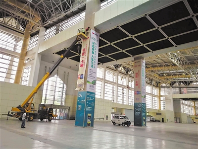 <p>　　布展公司安装参展商广告。本报记者　李峰　摄</p>