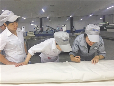 <p>　　学生（右）在师傅的指导下查看产品质量。（图片由受访者提供）</p>
