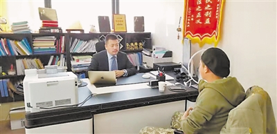 <p>　　律师孙龙（左）为市民提供法律咨询。</p>