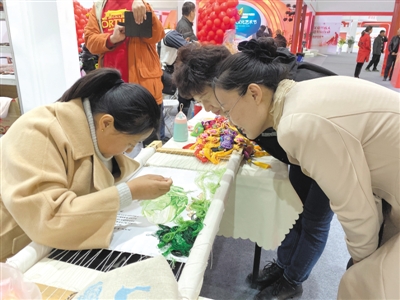 <p>　　田慧君（左）绣的白菜栩栩如生，吸引了市民观看。</p>