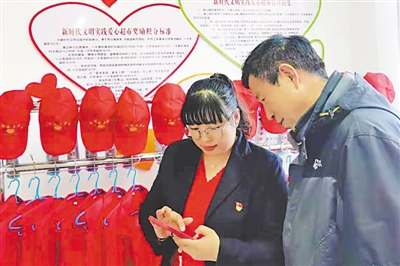 <p>　　　　邓振芳（左）帮助村民注册网购账号。</p>