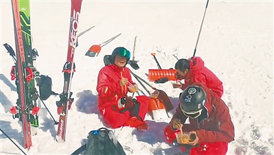 <p>　　队员训练结束后坐在雪地上吃饭。			　　（视频截图）</p>