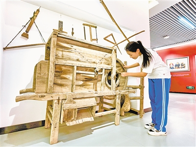 张文娣对旧式农具很好奇。