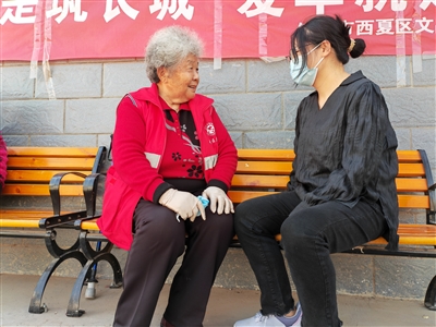 4月13日，李秀花（左）在社区与辖区居民交流。