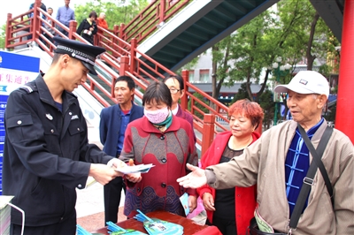 5月15日，中卫市沙坡头区公安分局民警在红太阳广场向过往群众宣传预防非法集资知识，并答疑解惑。本报记者 翟迎春 摄