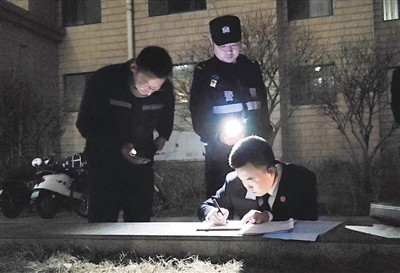 3月19日晚，兴庆区法院执行干警借着手机灯光为申请执行人办理执结手续。本报记者 段涛 摄