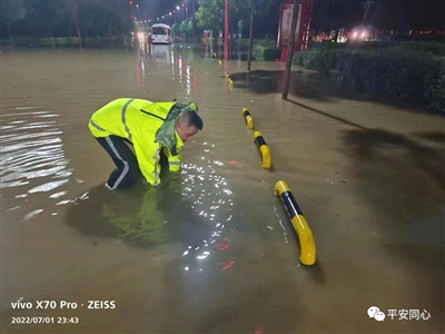 民警在积水中清理淤堵物。本报通讯员 苏玉萍 摄