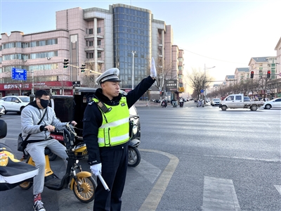 12月1日，周铁军在银川市上海路与民族街路口执勤，劝导车辆行人遵守交通规则。