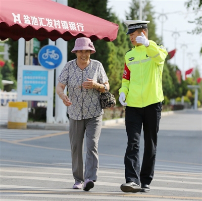 近日，交警引导老人安全过马路。本报通讯员 刘华 摄