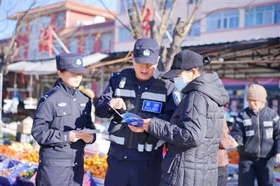     临近年末，民警在人群密集处一边巡逻，一边给群众开展反诈宣传。