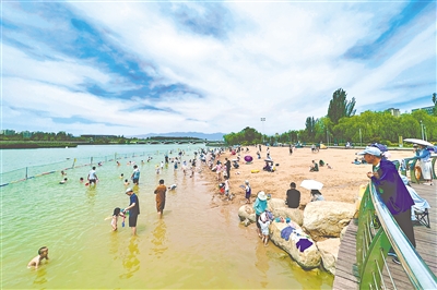 6月29日，银川阅海湾水上公园的沙滩上，市民在戏水、纳凉。连日来，银川市气温持续走高，市民纷纷走出家门，戏水享清凉。   	   本报记者 马楠 王洋 摄