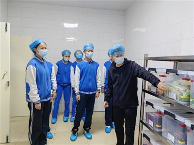     校方邀请学生参观餐厅后厨。