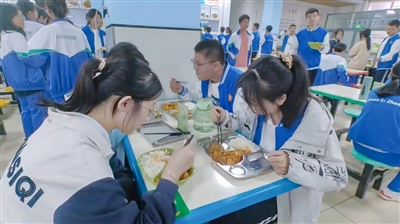     学生在餐厅品尝美味。