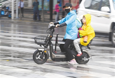 <p>　　　　细雨中走在街头的市民。</p>