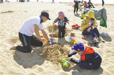 <p>　　在沙湖景区，父母带着两个孩子在沙滩上玩耍，尽享亲子时光。　　　							　　　　　　本报记者　李根成　钱建忠　摄</p>