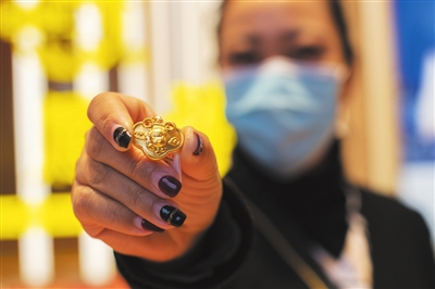 1月21日，在银川市兴庆区一家金店内，工作人员展示最热销的金牛锁。据介绍，春节越来越近，牛年元素的吊坠、转运珠、手镯、项链、摆件等饰品迎来热销。 

    本报记者  季正  摄