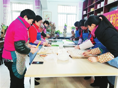 1月25日，银川市西夏区西花园路街道社区工作人员与外来务工人员一起包饺子。为做好疫情防控工作，西夏区倡导就地过年出实招，连日来，在社区推出送对联、送福字、送灯笼、送关爱系列活动，同时在各社区开展丰富多彩的“年味儿”活动，包饺子、吃团圆饭……让留下来的外来务工人员感受社区的“年味服务”，留在银川安心过春节。张雪梅  尉睿  摄影报道