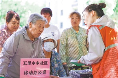 五里水乡社区将办公桌搬进小区，现场办公。