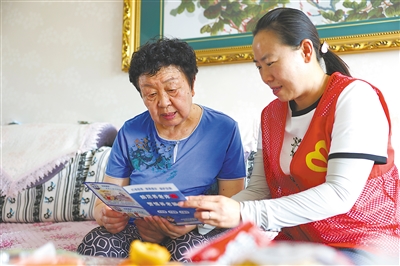     双城门社区工作人员张燕（右）到居民家中进行反诈宣传。
