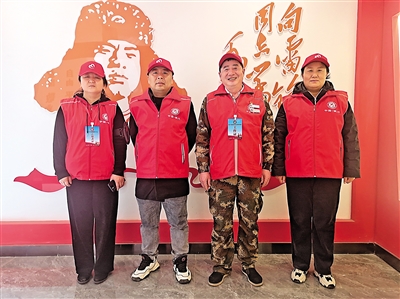 谢双义（右二）和一起做公益的志愿者，在银川市志愿服务联合会的雷锋墙前合影。