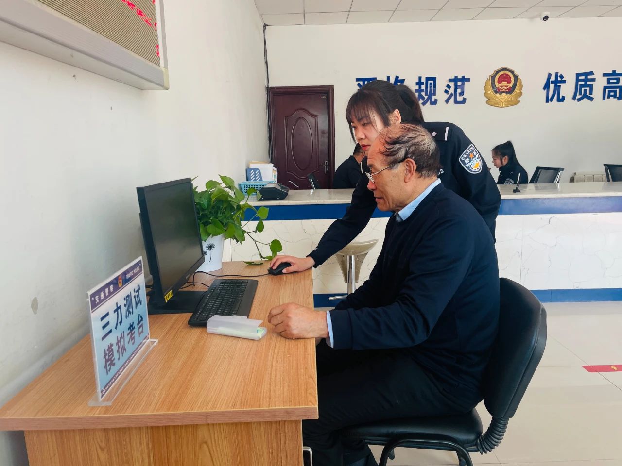 民警指导老年人用电脑模拟答题.jpg