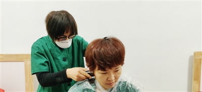     王晓霞帮队友理发。