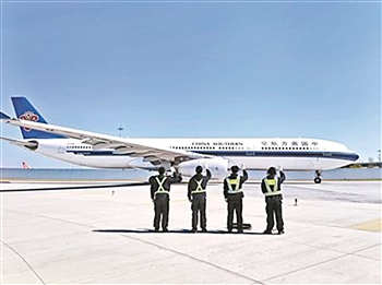 “飞机拜拜员”向机组、乘客和飞机挥手道别。资料图片