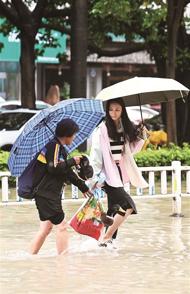 5月19日，市民从南宁东葛路积水处通过。受高空槽、低涡切变和地面冷空气共同影响，5月18日8时至19日10时，广西出现一次大范围降雨过程。   新华社发