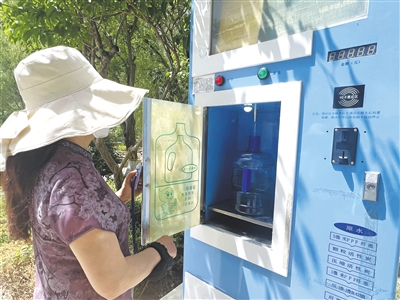 贺兰县恒大御景半岛小区的居民在直饮水机上取水。