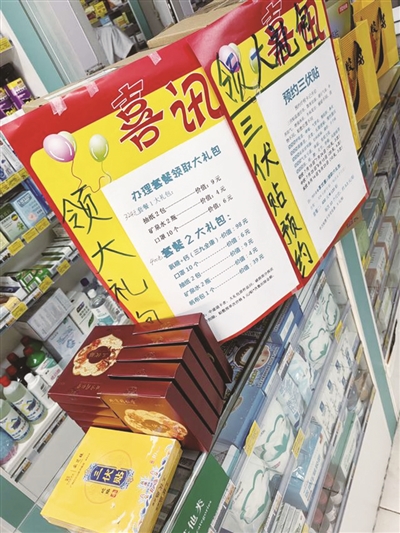 一家药店柜台处摆放着盒装三伏贴和预约广告。