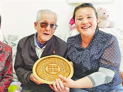 <p>　　李红梅（右一）为社区老人蔡树良送上定制的“民族团结”月饼。</p>