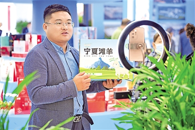     展会现场，一位参展商正在网络直播销售精分割宁夏滩羊肉。