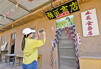     游客在电视剧《山海情》的取景地拍照留念。