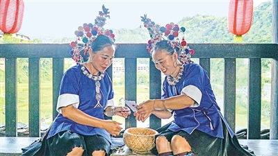     程阳桥上，侗族妇女在展示制作侗族刺绣产品。绣品图案精美、色彩艳丽，成为当地特色产业。