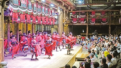     8月27日，在广西桂林市龙胜各族自治县龙脊镇黄洛瑶寨，红瑶姑娘表演晒红衣，红瑶梳长发等特色活动。黄洛瑶寨共有83户，348人，获评“首批中国少数民族特色村寨”。